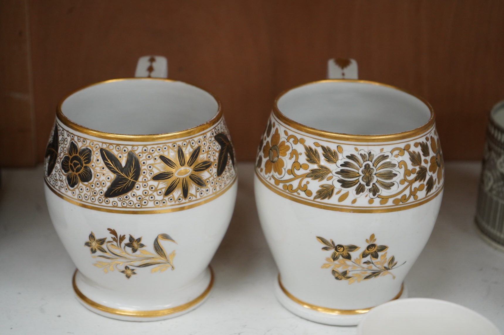 A pair of early 19th century English porcelain large mugs with gilt bands and five other early 19th century porcelain or pearlware mugs, one inscribed SG, Forget Me Not, largest each 14cm high